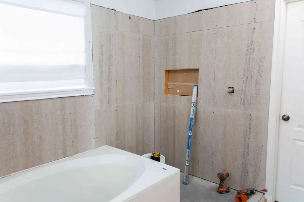 What do you put behind cement board in shower