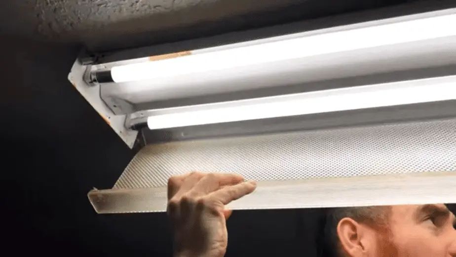 How do you remove the cover on a fluorescent light fixture