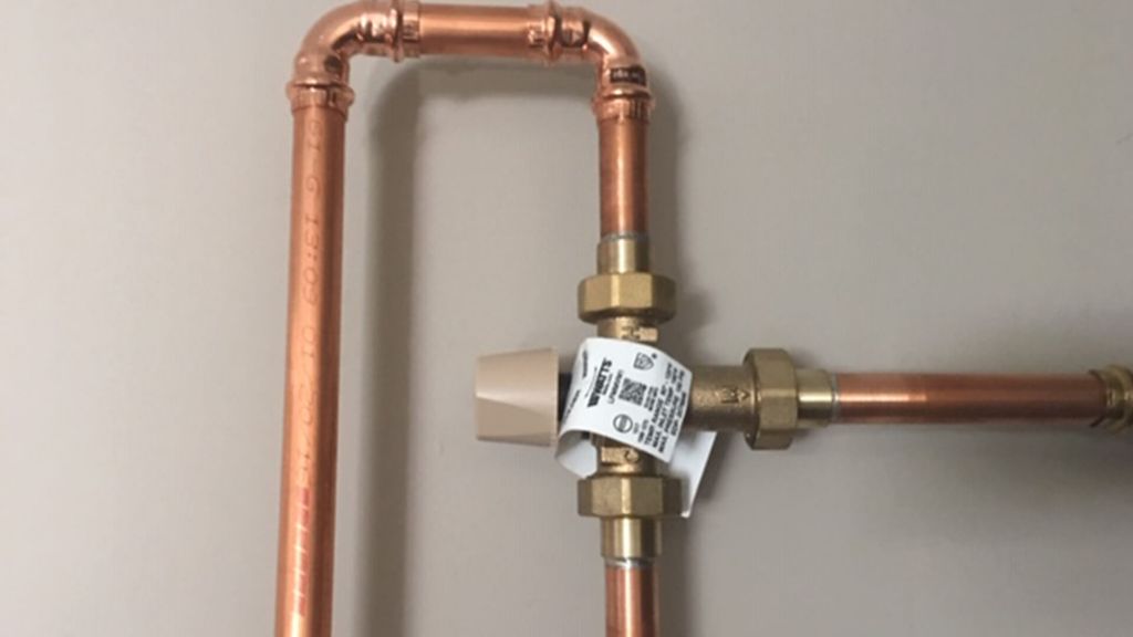 What does a mixing valve do on a water heater