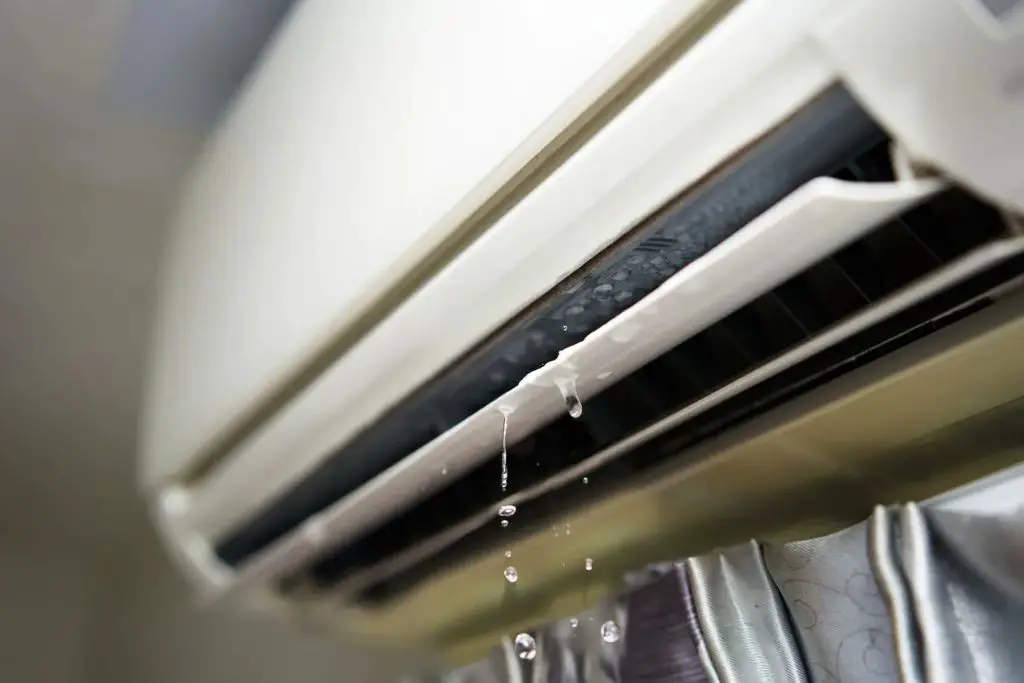 How do I stop my window air conditioner from spitting up water