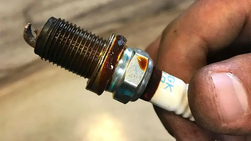 What causes oil in the spark plug hole